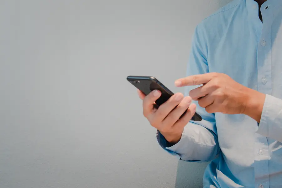 A citizen using their phone to fill out an application for a business license (or a contractor using their phone to fill out an application for a building permit) online through iWorQ's Portal Home.