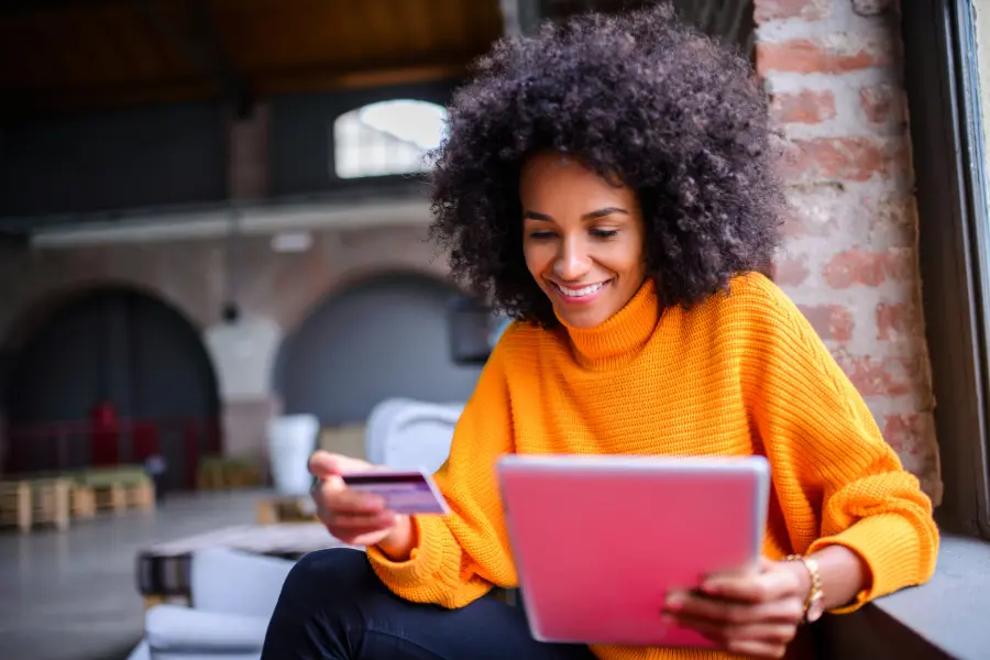 A woman using a credit card to pay online for her business license through iWorQ's Portal Home Software.
